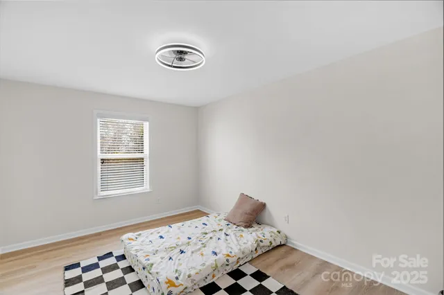 a bedroom with a bed and wooden floor