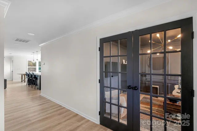 a hallway with a view of living room and wooden floor