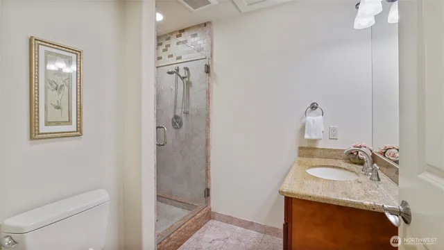 a bathroom with a granite countertop sink toilet and shower