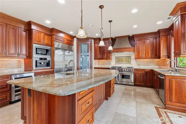 a kitchen with stainless steel appliances granite countertop a stove a sink a oven a dining table and chairs