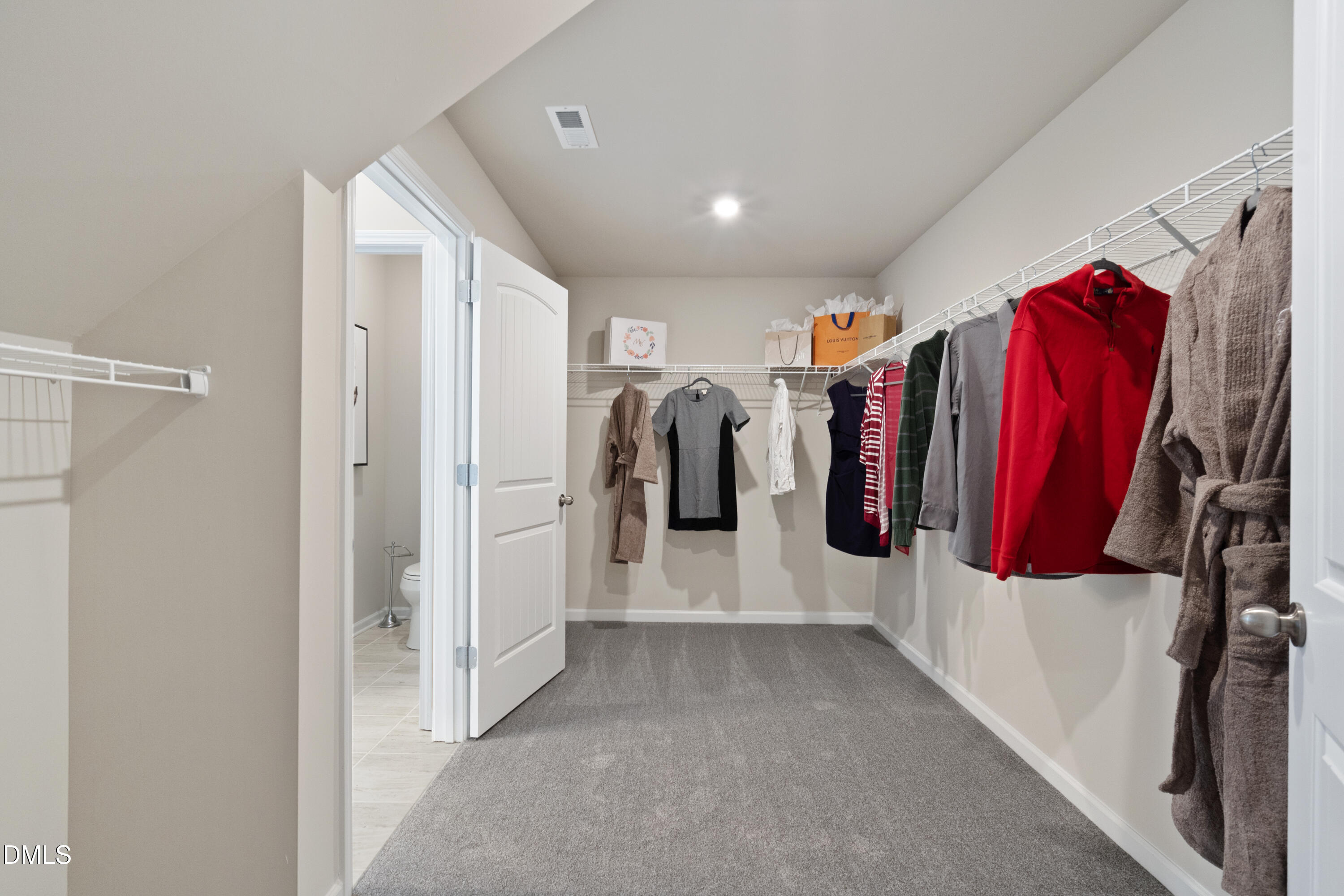 311 White Azalea Way Benson, NC 27504 - Photo 19 of 26 a view of walk in closet with clothes