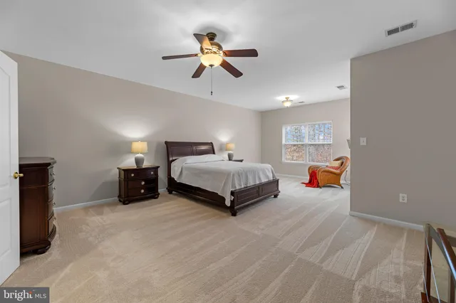 a spacious bedroom with a bed and a chandelier