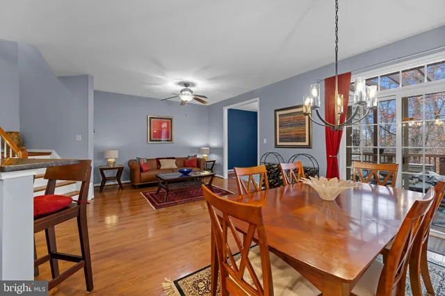 a dining room with furniture a chandelier and wooden floor