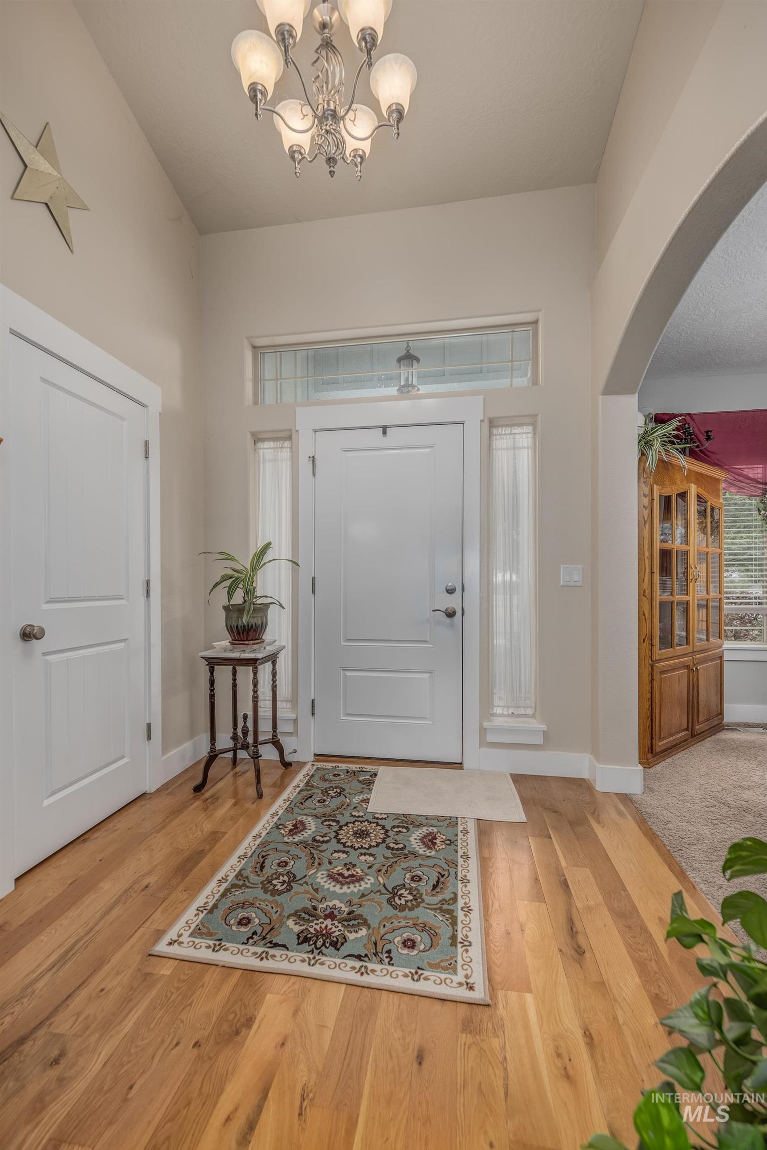 420 West Indianhead Road Weiser, ID 83672 - Photo 5 of 40 Entryway featuring high vaulted ceilings, light wood-finish flooring, and an arched doorway