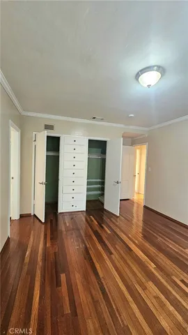 an empty room with wooden floor and closet
