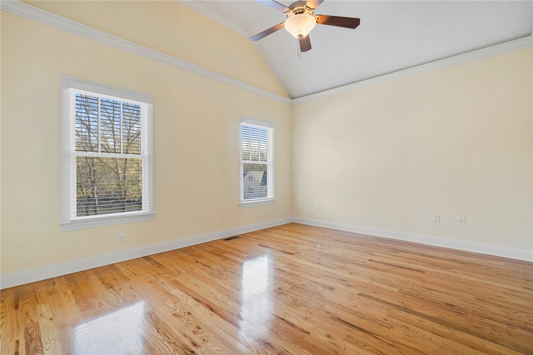 16 Oleander Drive Anderson, SC 29621 - Photo 21 of 37 Vast hardwood flooring extends beneath high vaulted ceilings and a ceiling fan in this naturally illuminated bedroom.