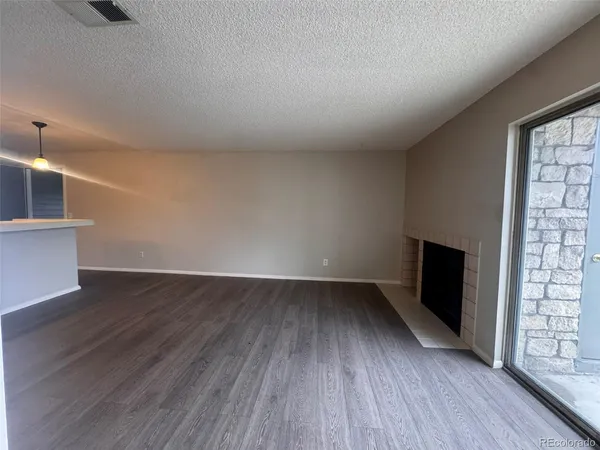 a view of empty room with wooden floor and fireplace