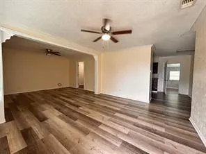 a view of a livingroom with wooden floor and a ceiling fan