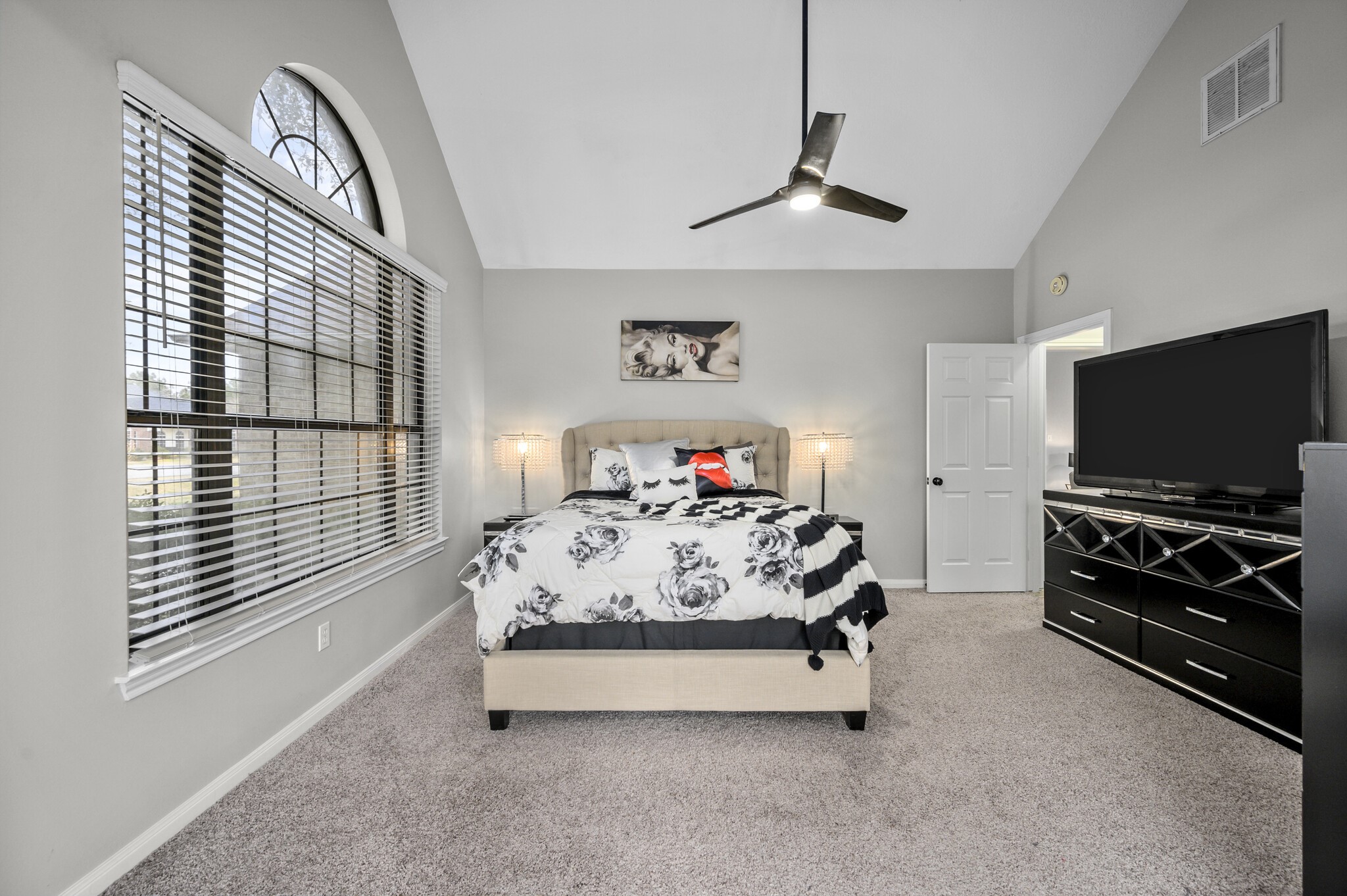 12302 Fisher Drive Mont Belvieu, TX 77523 - Photo 16 of 23 a bedroom with a bed and a flat tv screen on the dresser
