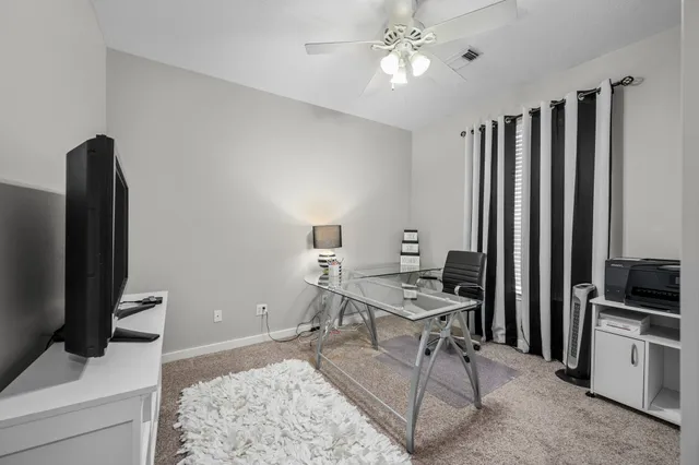 a view of a workspace with furniture and a flat screen tv