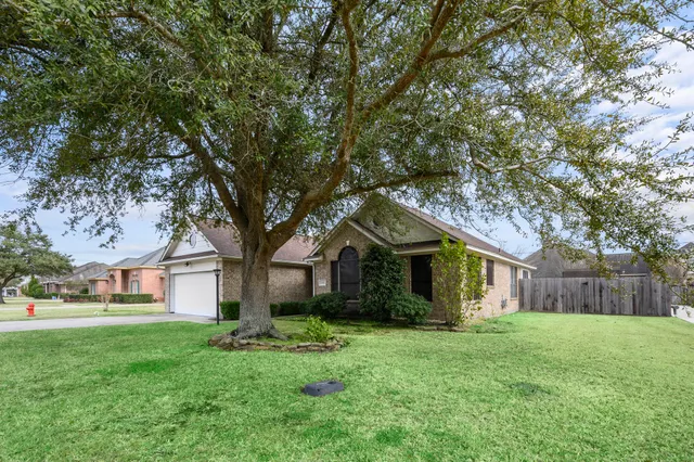 a front view of a house with a garden and trees