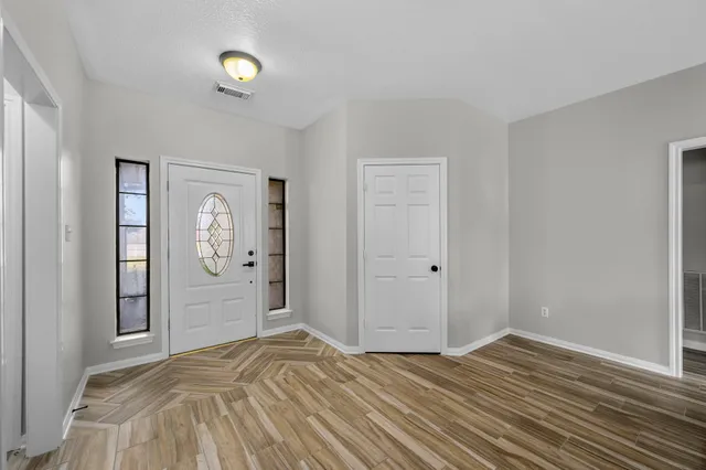 a bedroom with wooden floor and window