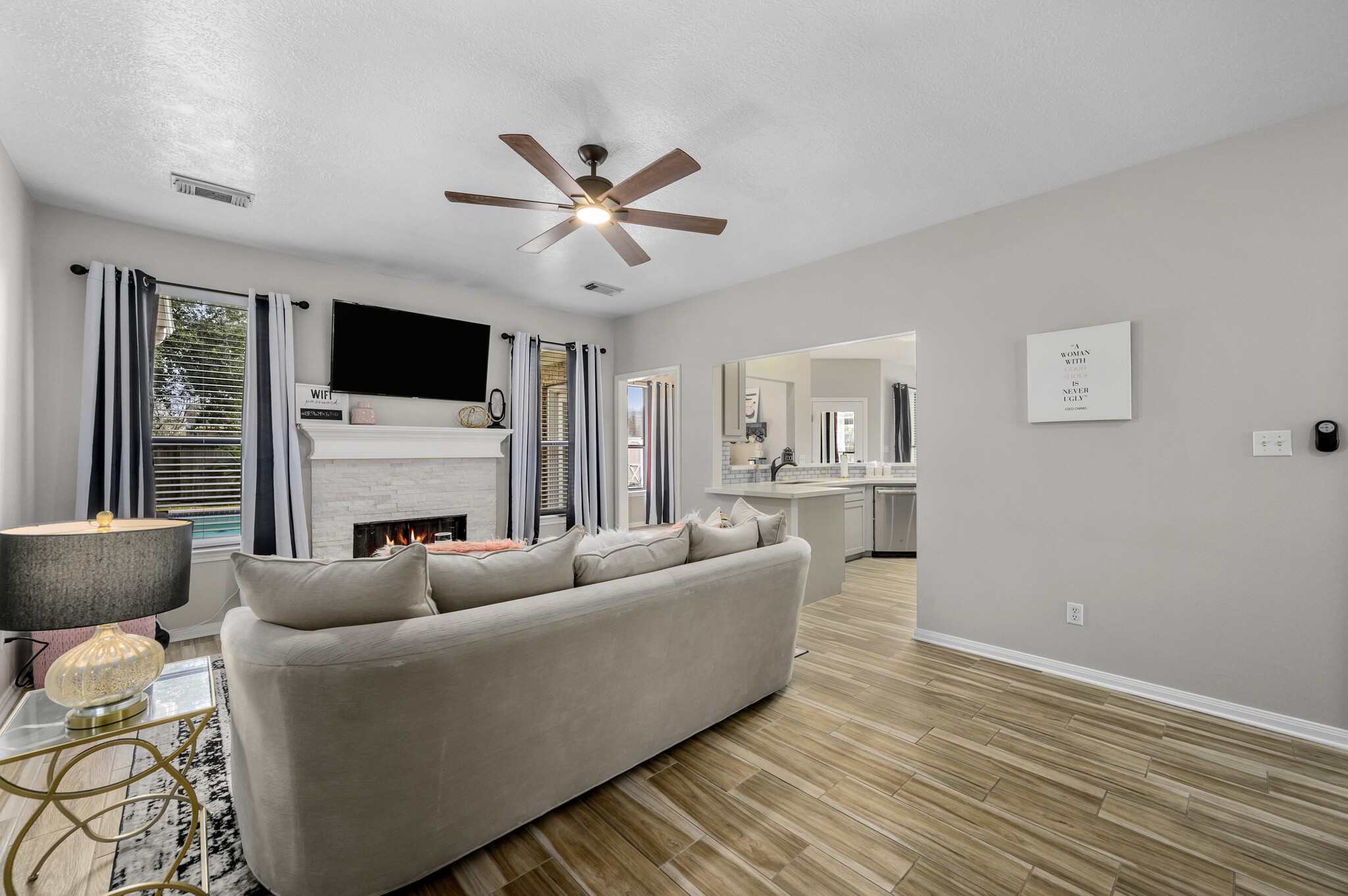 12302 Fisher Drive Mont Belvieu, TX 77523 - Photo 5 of 23 a living room with furniture a fireplace and a flat screen tv