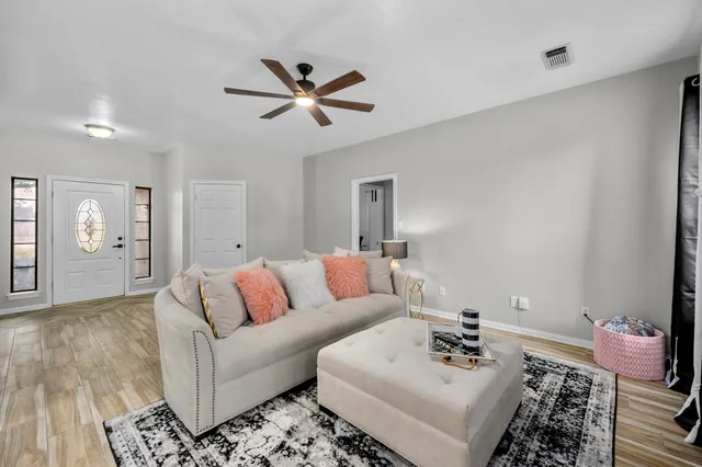 a living room with furniture and wooden floor