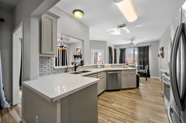 a large kitchen with a sink and refrigerator