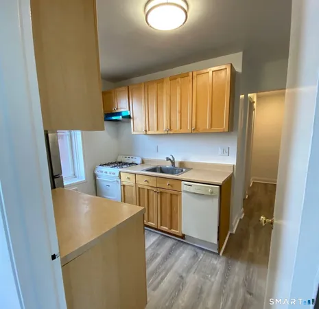 a kitchen with stainless steel appliances a refrigerator sink and wooden cabinets