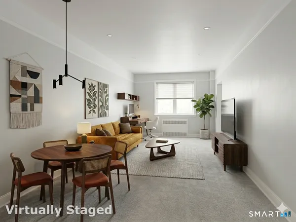a living room with furniture a flat screen tv and a window