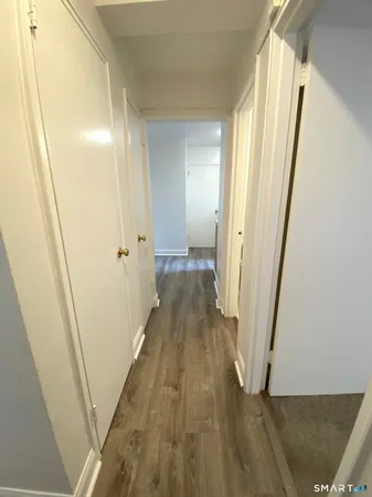 a view of a hallway with wooden floor and staircase