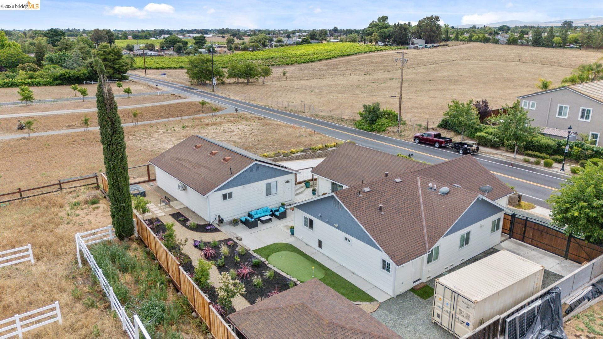 700 Brownstone Road Oakley, CA 94561 - Photo 9 of 58 Aerial view showcasing multiple structures, a putting green, and a landscaped patio area