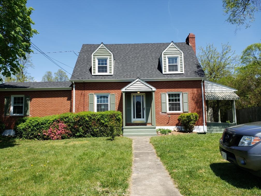 a front view of a house with a yard and potted plants
