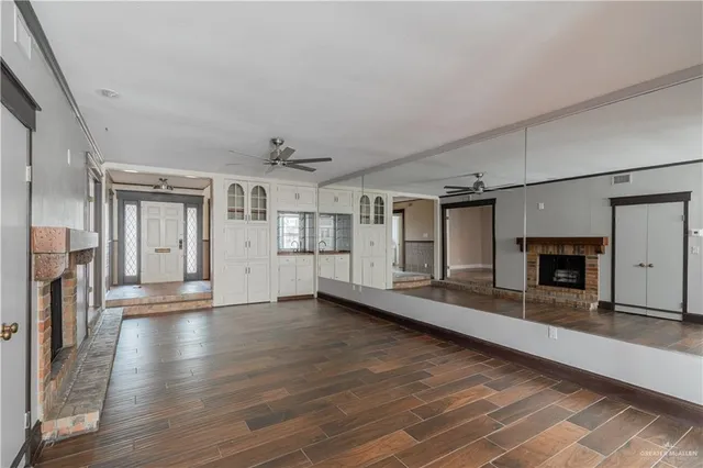 a view of a livingroom with wooden floor and a fireplace