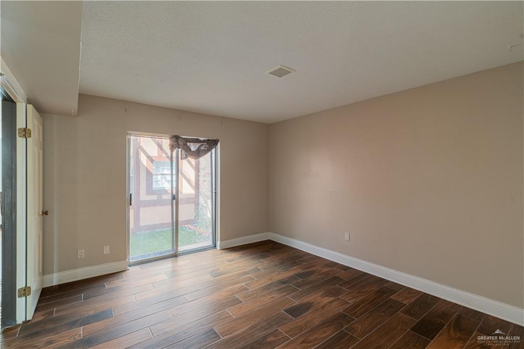 1004 South Border Avenue Weslaco, TX 78596 - Photo 6 of 20 a view of an empty room with wooden floor and a window