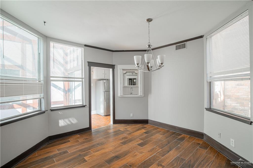 1004 South Border Avenue Weslaco, TX 78596 - Photo 8 of 20 a view of an empty room with a window and wooden floor