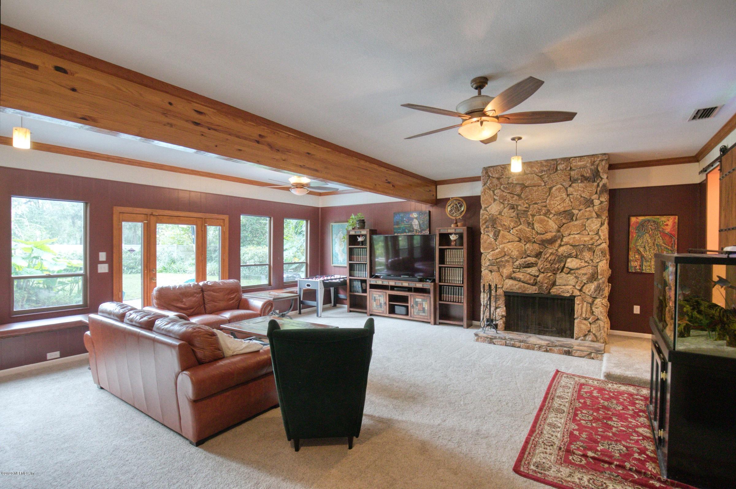 9439 Conifer Road Jacksonville, FL 32257 - Photo 23 of 60 a living room with furniture fireplace and a large window