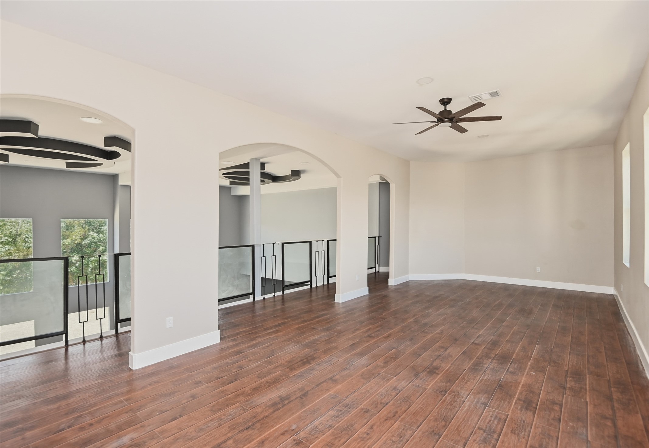 14300 Fallen Timber Drive Austin, TX 78734 - Photo 28 of 35 a view of an empty room with wooden floor and a ceiling fan