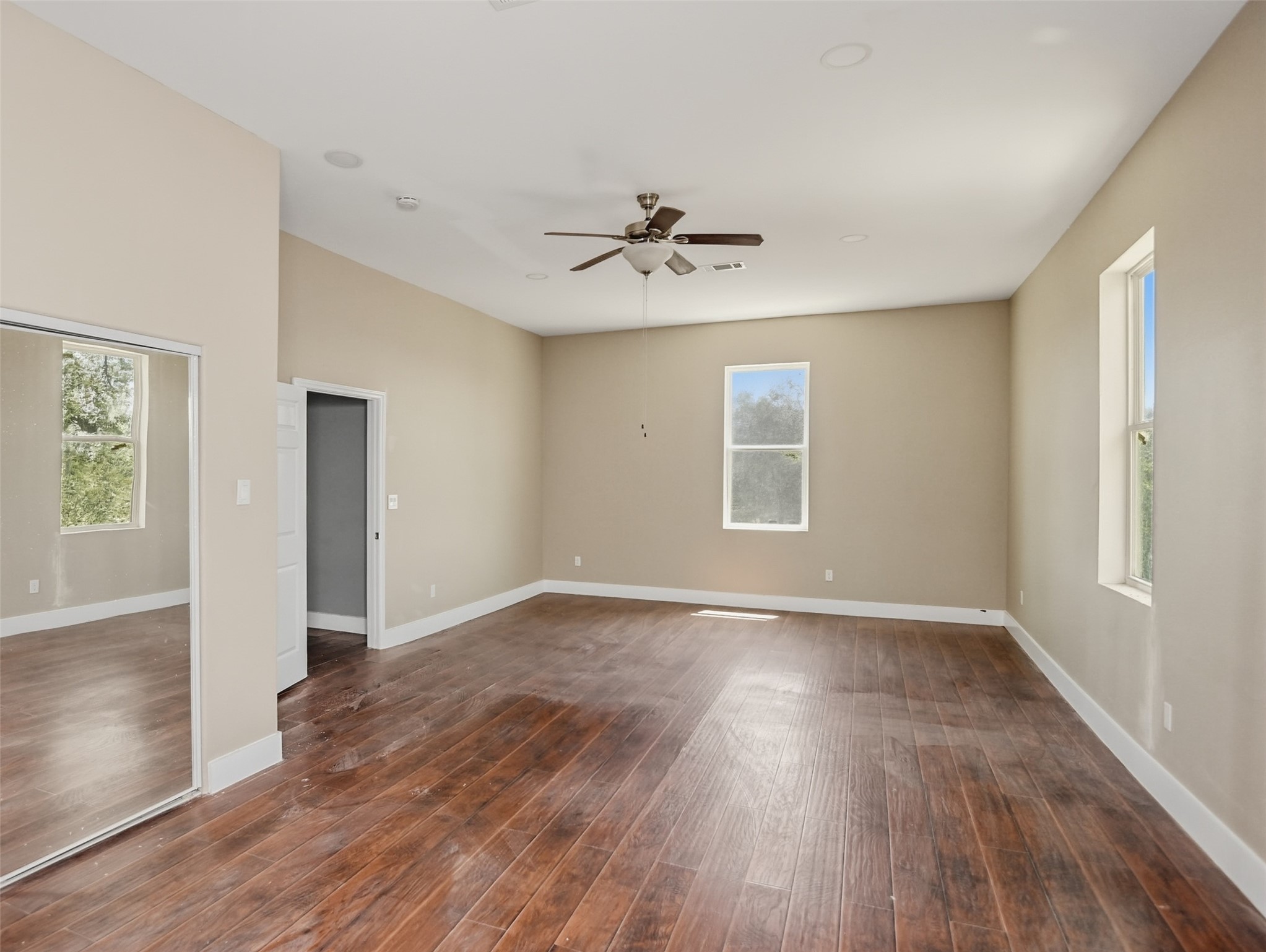 14300 Fallen Timber Drive Austin, TX 78734 - Photo 31 of 35 an empty room with wooden floor ceiling fan and windows