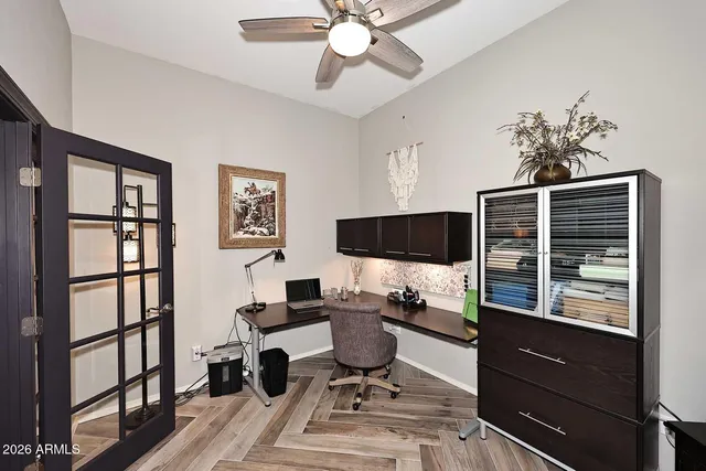 a view of a workspace with furniture and a window