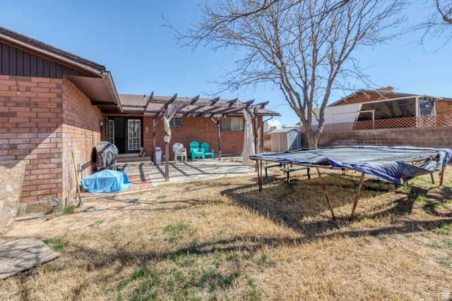 3334 Ute Road St. George, UT 84790 - Photo 37 of 40 Fenced backyard featuring a pergola, a storage shed, a patio area, and a covered pool