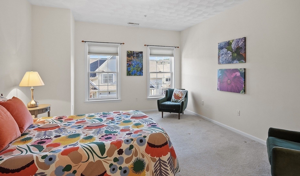 802 Autumn Ridge Drive, Unit 802 Ayer, MA 01432 - Photo 17 of 32 a bedroom with a bed and a lamp on dresser