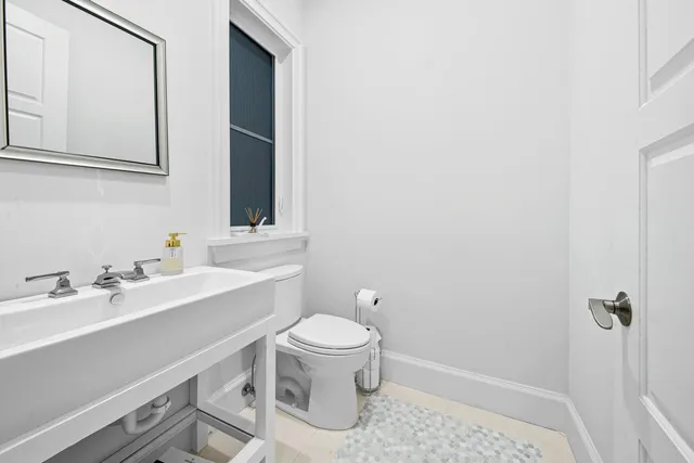 a large white kitchen with a large island in the center and a large window