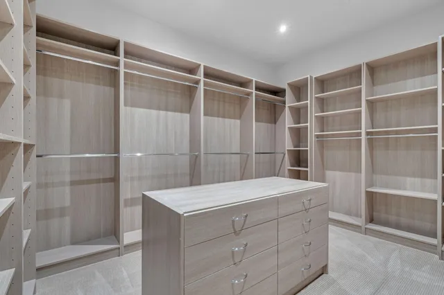 a view of walk in closet with empty racks