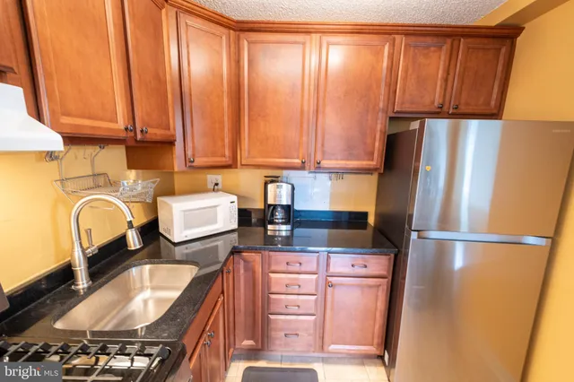 a kitchen with stainless steel appliances granite countertop a refrigerator sink and cabinets
