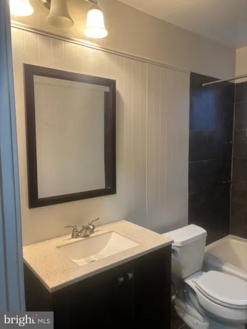 a bathroom with a sink a toilet a mirror and shower