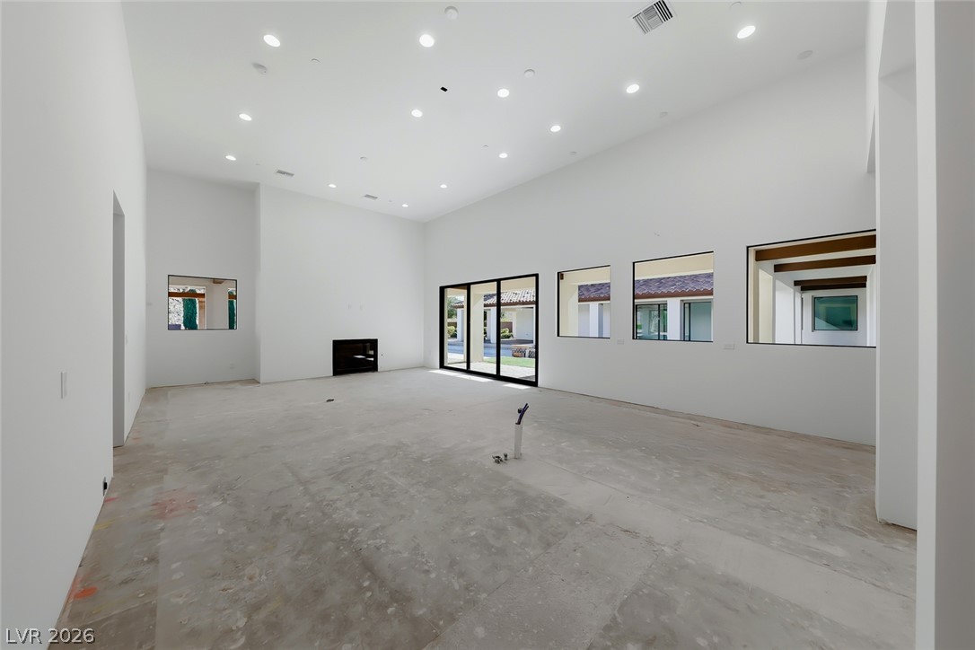 1140 Julie Road Henderson, NV 89002 - Photo 45 of 71 A spacious, naturally illuminated room featuring a modern fireplace and sliding glass doors that open to the outdoors.