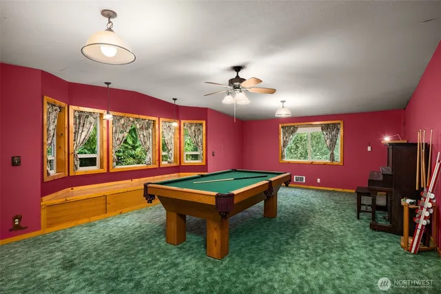 a room with pool table and windows