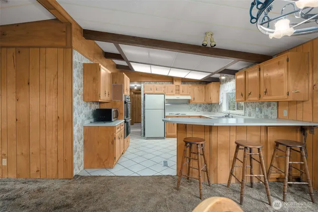 a kitchen with stainless steel appliances granite countertop a table chairs sink and cabinets