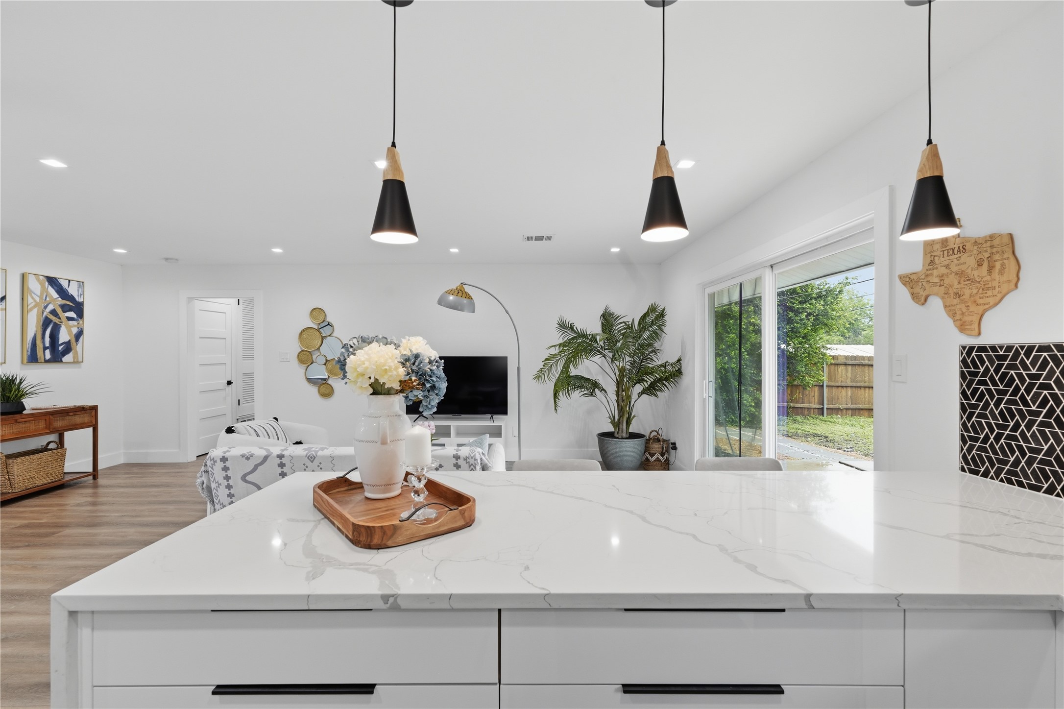 5604 Coventry Lane Austin, TX 78723 - Photo 11 of 33 Kitchen island featuring a white countertop with subtle veining and dark hardware on white cabinetry