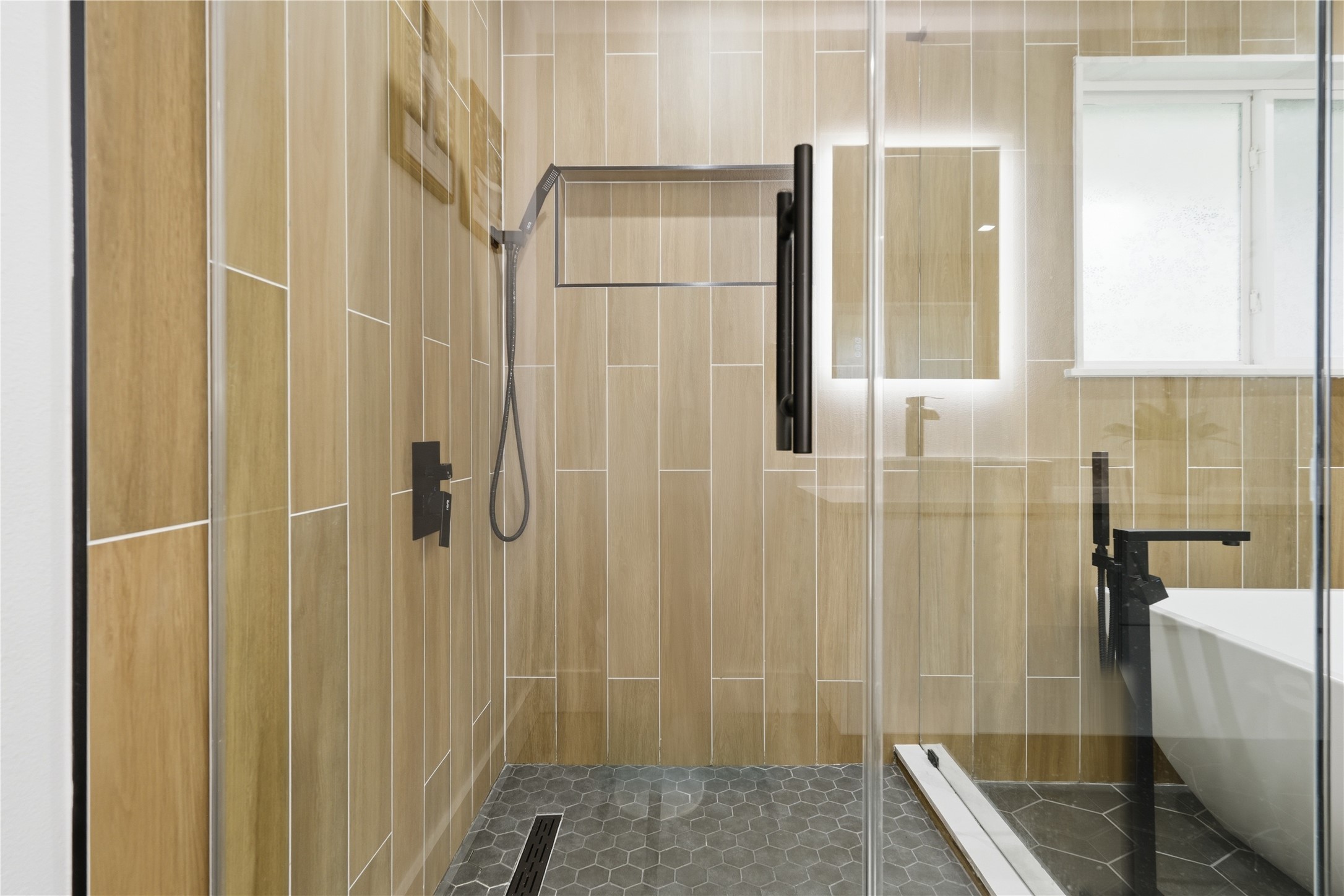 5604 Coventry Lane Austin, TX 78723 - Photo 23 of 33 Glass-enclosed shower featuring wood-finish wall tiling and hexagonal floor tiling