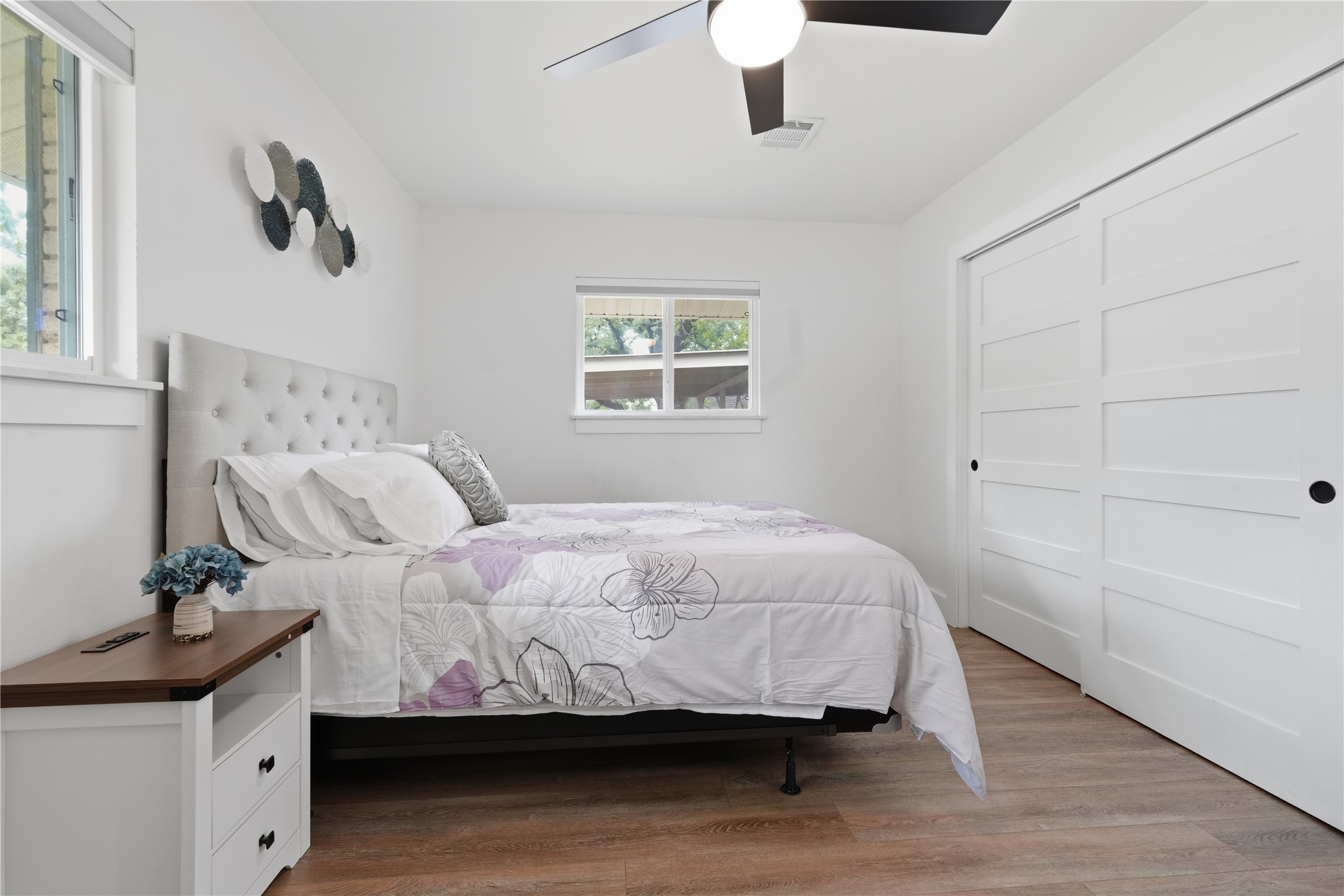 5604 Coventry Lane Austin, TX 78723 - Photo 27 of 33 Bedroom featuring wood-finish flooring, white walls, and a ceiling fan with integrated lighting
