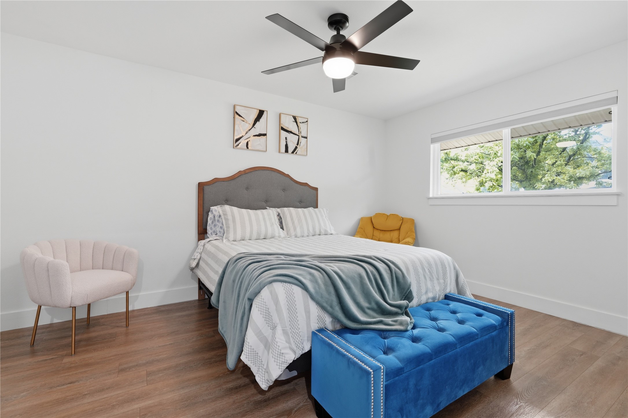 5604 Coventry Lane Austin, TX 78723 - Photo 29 of 33 Bright room featuring wood-finish flooring, a contemporary ceiling fan with integrated lighting, and a wide window providing natural illumination
