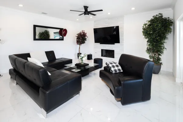 a living room with furniture a flat screen tv and a fireplace