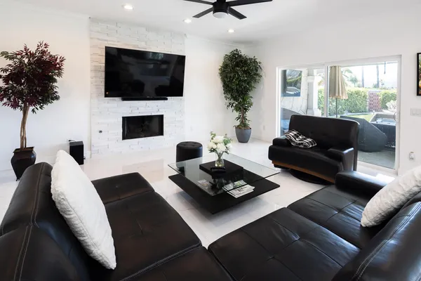 a living room with furniture a flat screen tv and a large window