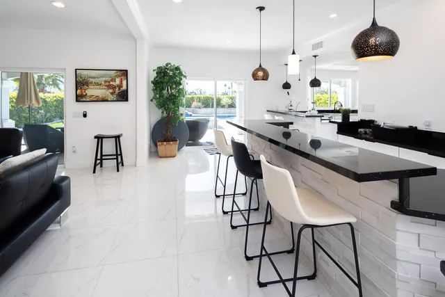 a kitchen with stainless steel appliances kitchen island a table and chairs in it