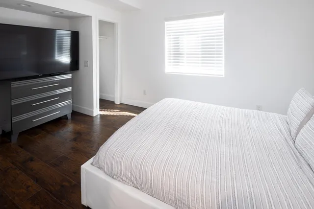 a bedroom with a bed and flat screen tv