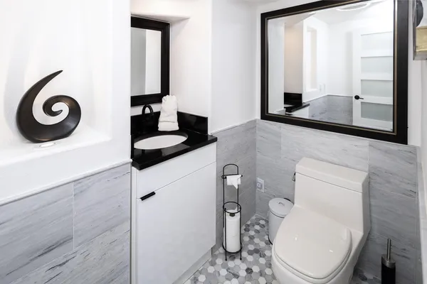 a bathroom with a toilet a sink and mirror