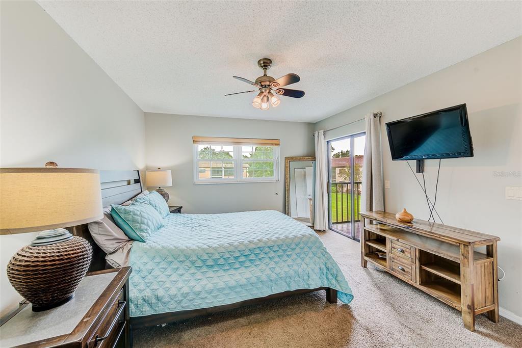 12900 Vonn Road, Unit E205 Largo, FL 33774 - Photo 14 of 35 a bedroom with a bed and a flat screen tv